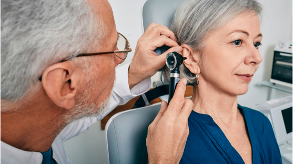 Village Medical primary care physician examining a woman’s ear for fluid from the ear