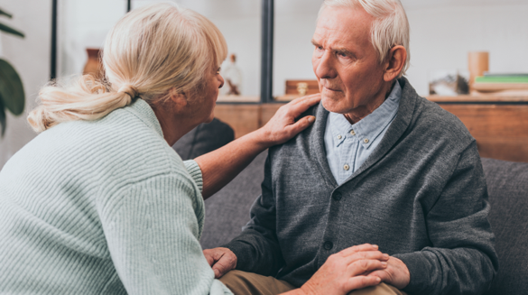 An older man with hereditary dementia looking at a woman