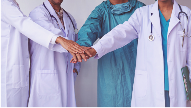 Village Medical coordinated care doctors stacking their hands