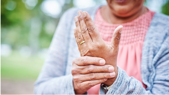 A person holding their hand to alleviate arthritis symptoms