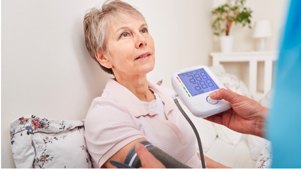 Village Medical provider measuring a woman’s blood pressure and circulatory health