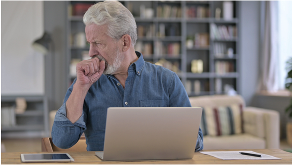 Man sitting at his desk coughing up mucus