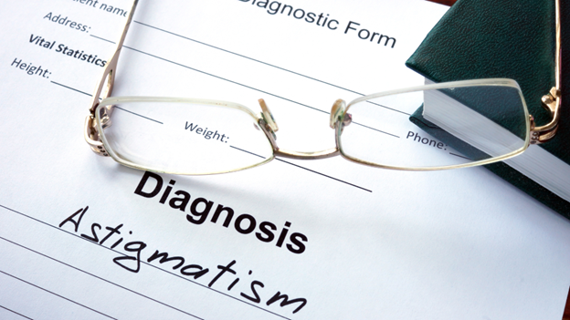 A pair of glasses resting on a diagnostic form from Village Medical about astigmatism